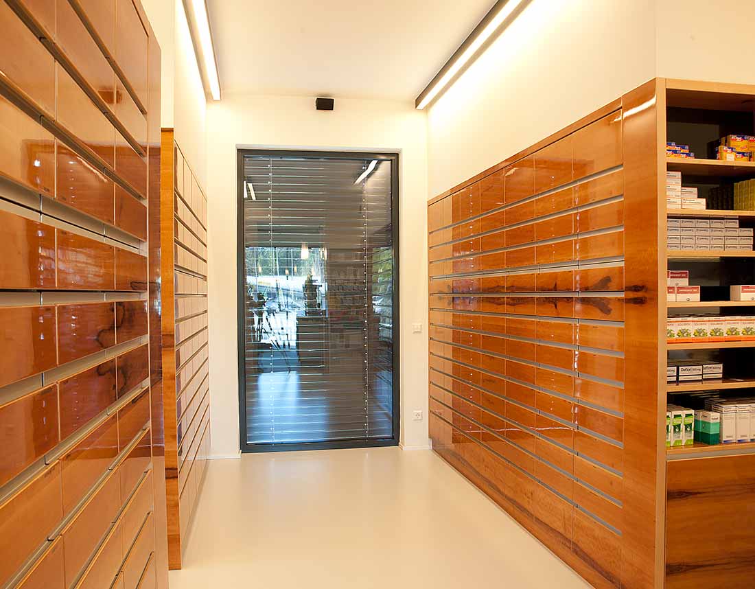 Apotheke mit farbig lackierten Glas- und Holzelementen.