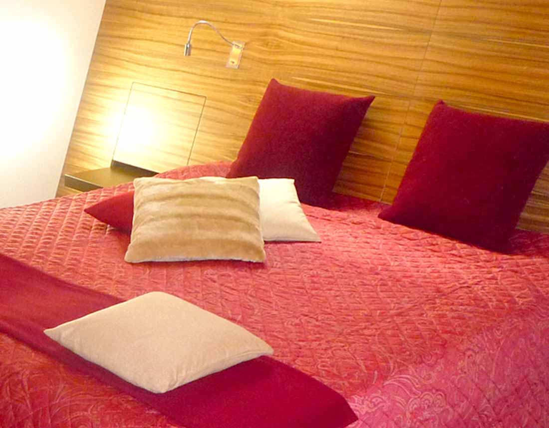 Großes Doppelbett mit Kopfhaupt über die ganze Wandbreite