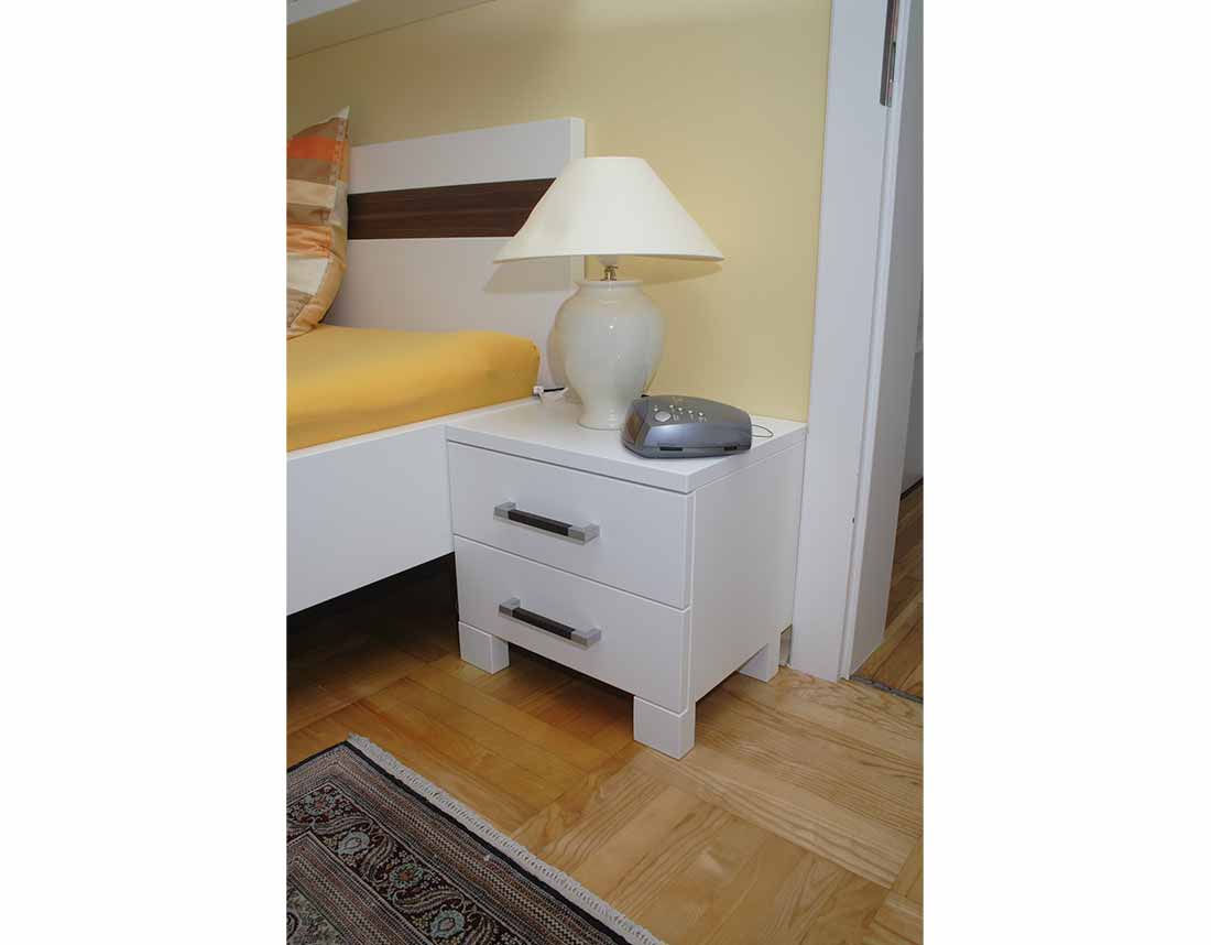 Doppelbett und Nachtschrank in Weiß.
