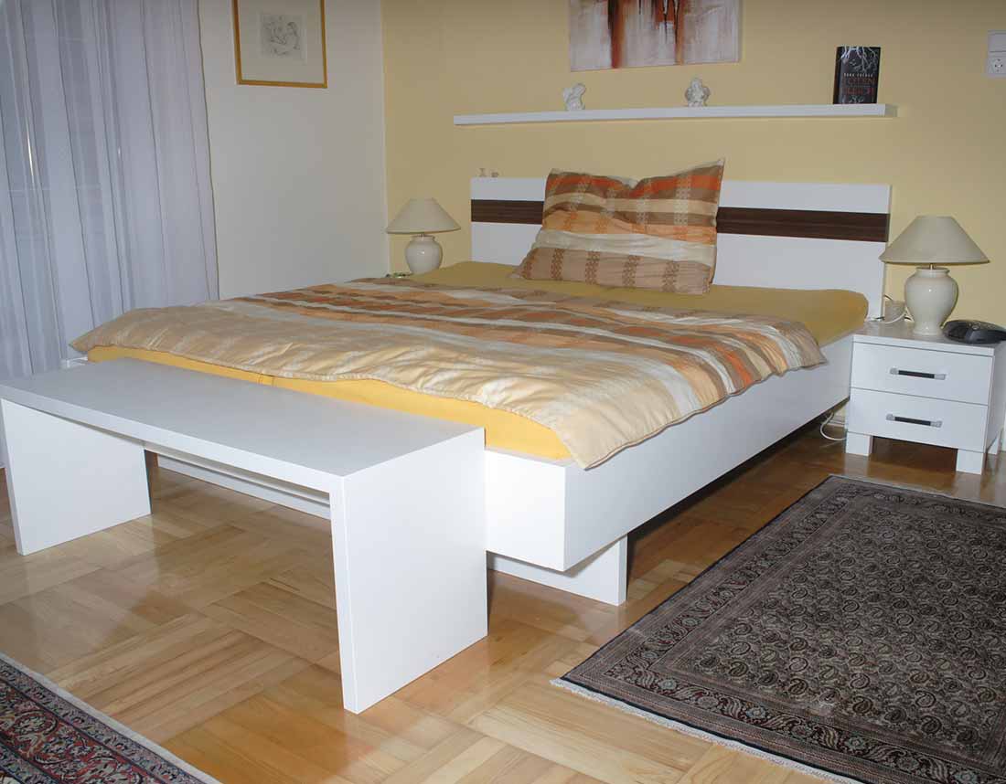 Schwebendes Doppelbett mit weißem Gestell.