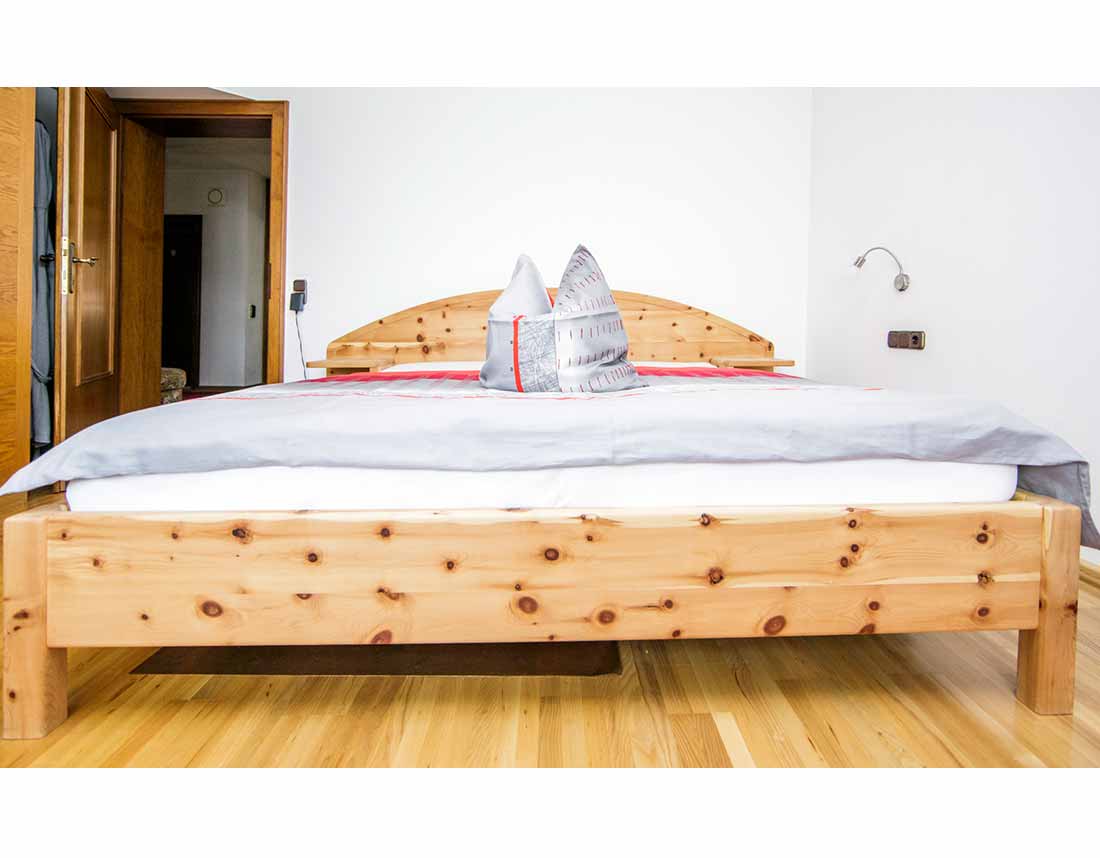 Breites Doppelbett aus Zirbenholz.