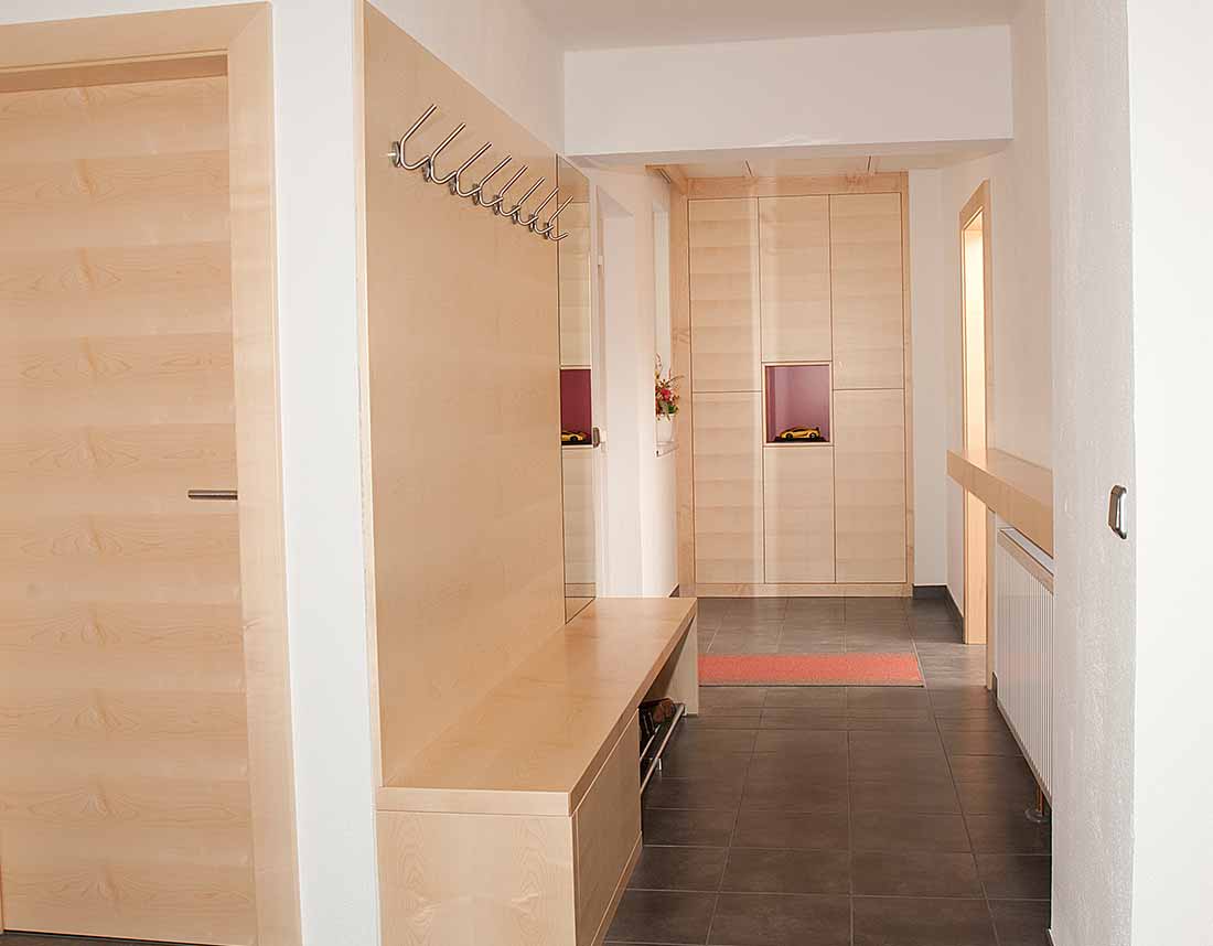 Helle Garderobe mit Stauraum und Wandhaken.