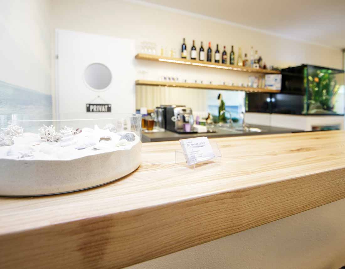 Eine moderne Bar mit Eschenholzplatte und drei schwarzen Barhockern.