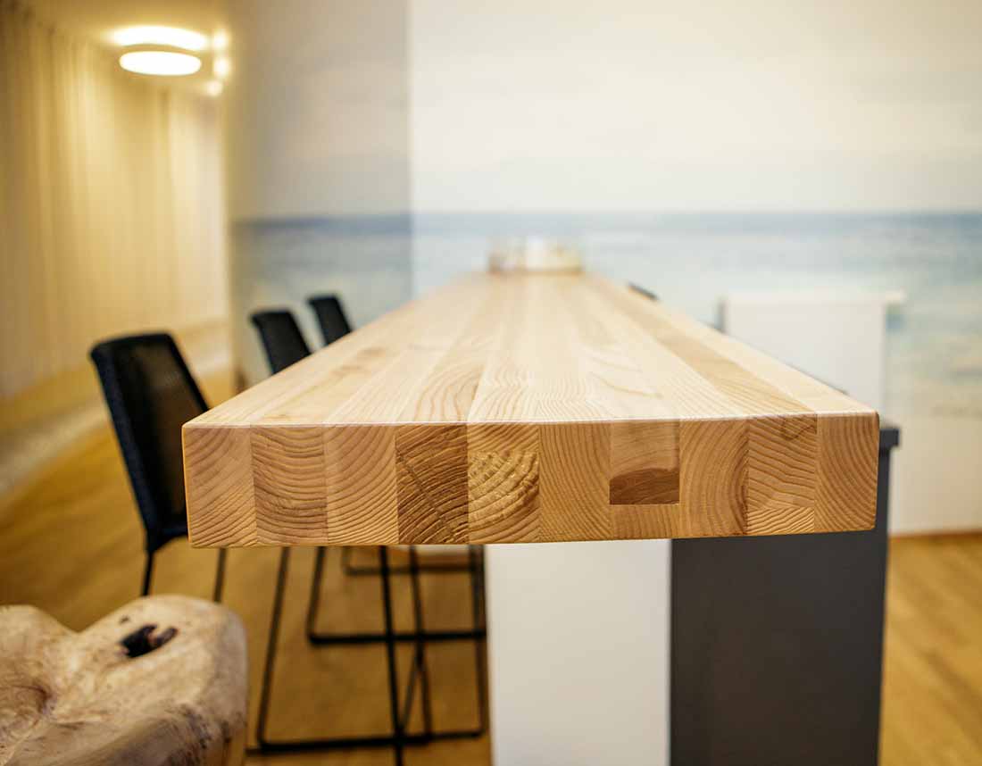 Detailansicht der hellen Eschenholz-Pultplatte in einer Bar.