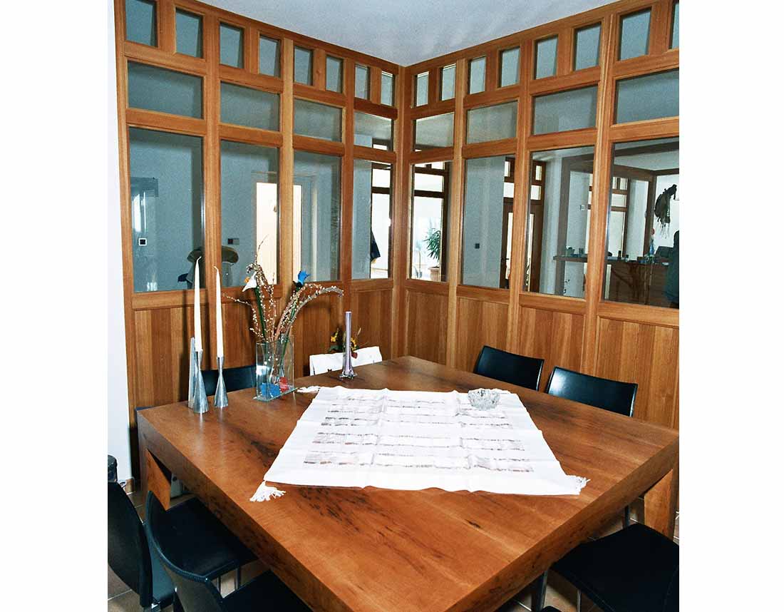 Esszimmer mit Holzvertäfelung und großem Esstisch.