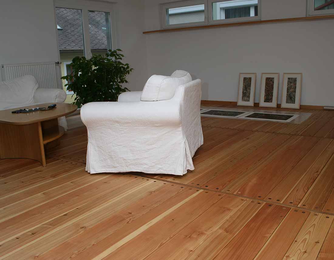 Wohnzimmer mit Dielenboden und weißer Couch.