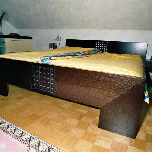 Schlafzimmer mit großem Doppelbett und passenden Nachttischen aus dunklem Holz.