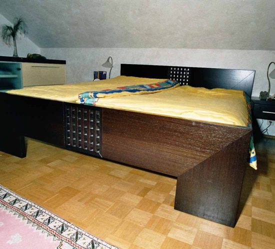 Schlafzimmer mit großem Doppelbett und passenden Nachttischen aus dunklem Holz.