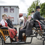 Vier Personen sitzen auf den hinteren Sitzen einer Kutsche