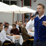 Redner wirft Gästen ein lachen ins Gesicht bei der Firmenfeier