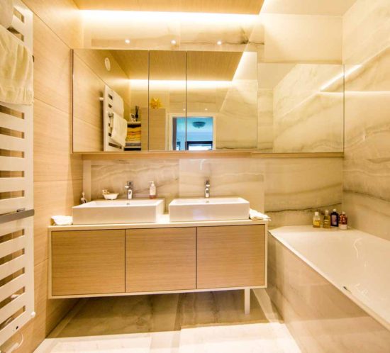 Modernes Badezimmer mit zwei Waschbecken und Badewanne.