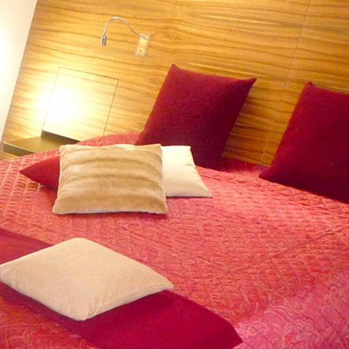 Großes Doppelbett mit Kopfhaupt über die ganze Wandbreite