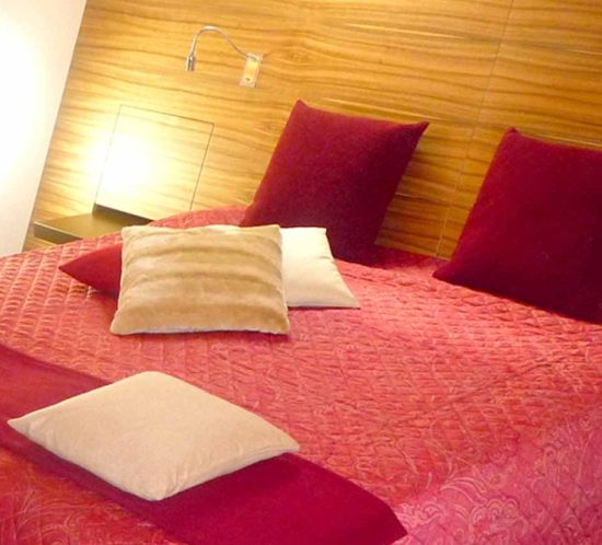 Großes Doppelbett mit Kopfhaupt über die ganze Wandbreite
