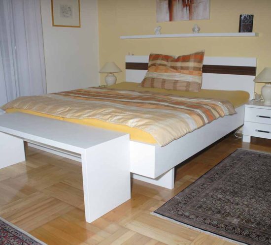 Schwebendes Doppelbett mit weißem Gestell.