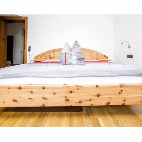 Breites Doppelbett aus Zirbenholz.
