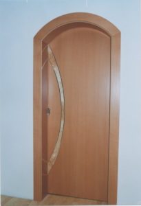 Moderne Holztür mit ovalem Glaseinsatz und geschwungenem Türrahmen.