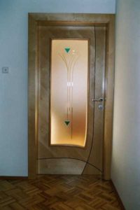 Holztür mit mattem Glaseinsatz und dekorativen Mustern.