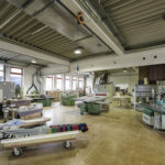 Eine geräumige Werkstatt mit verschiedenen Maschinen und Arbeitsplätzen für Holzarbeiten.