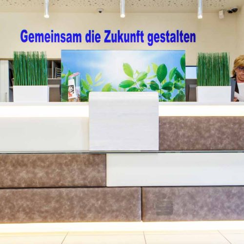 Empfangstheke mit Polsterelementen in Beige und Braun.