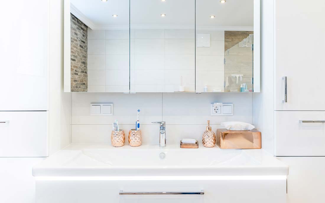 Badezimmer-Waschbecken mit Spiegeln und dekorativen Seifen- und Zahnbürstenhaltern.