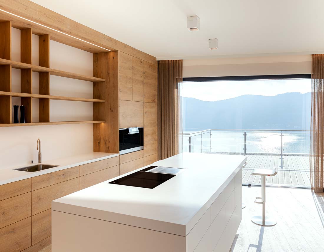 Moderne Küche mit Holzverkleidung und Seeblick.