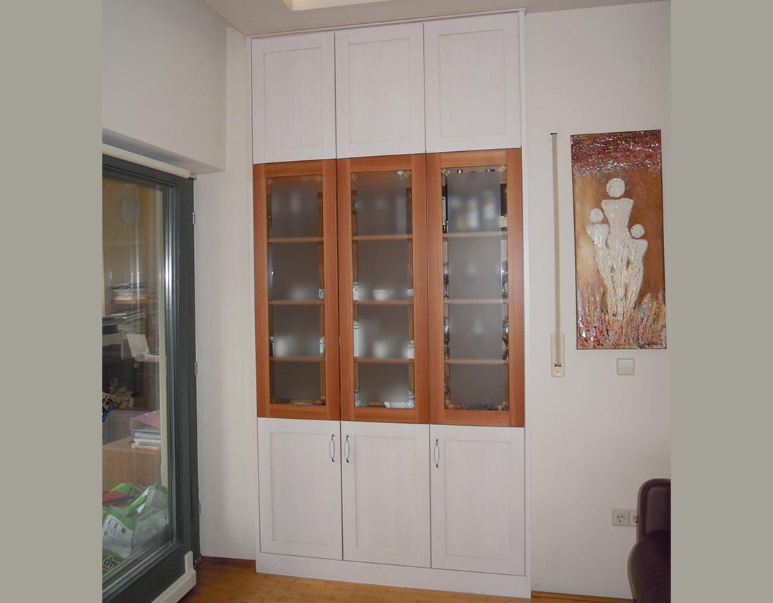 Eingebauter Schrank mit Milchglastüren und Holzrahmen.