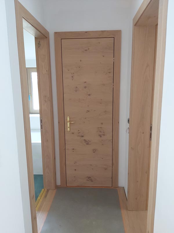 Geschlossene Holztür in einem Flur.