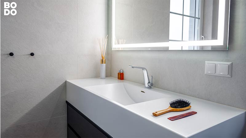Moderner Waschtisch im Badezimmer mit Spiegel, Duftstäbchen und Bürste
