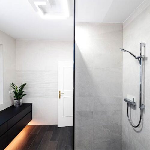 Modernes Badezimmer mit bodenebener Dusche und schwarzer Kommode