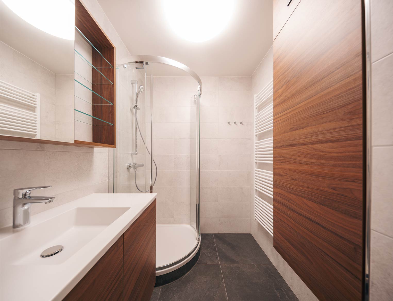 Modernes Badezimmer mit Duschkabine und Holzdetails.